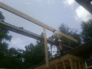 Carpenter setting a ridge beam over a new addition frame — Ice Dam Removal by Roofing Brothers in New Ipswich