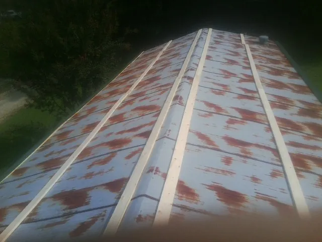 Rusted metal roof panels with new wood purlins before replacement — Storm Damage Roof Repair in New Ipswich by Roofing Brothers