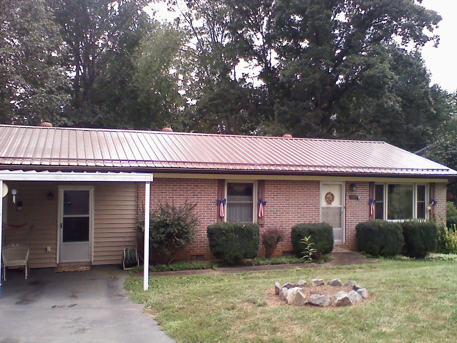 Bronze metal roof and carport on a brick ranch home — Roof Repair work by our crew in New Ipswich